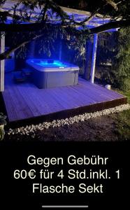 uma banheira de hidromassagem sentada num deque de madeira à noite em Kleine Wohnung in schöner Villa em Meerane