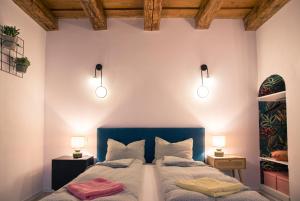 een slaapkamer met 2 bedden en verlichting aan de muur bij Seek and Hide - Csilla's Tiny Hideaway in Braşov