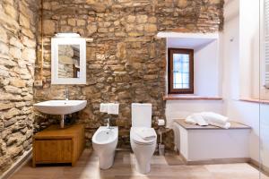 a stone bathroom with a toilet and a sink at Affittacamere La Rocca Campiglia in Campiglia Marittima