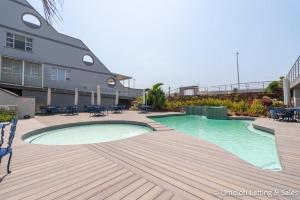 a swimming pool on a deck next to a building at Coastal Nest in Durban North