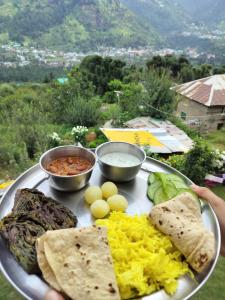 een bord met eieren, kaas en andere voedingsmiddelen bij MyTribe Homestay in Manāli