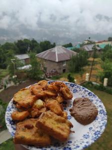 een bord eten met uitzicht op een huis bij MyTribe Homestay in Manāli