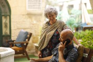 una mujer hablando en un celular junto a un hombre en Al Yasmeen Hotel, en Nablus