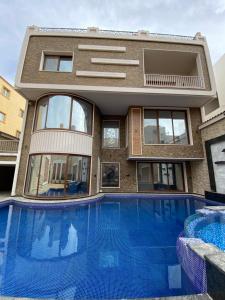 a house with a swimming pool in front of a building at black tiger villa in ‘Ezbet `Abd el-Ḥamîd