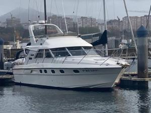 un barco blanco atracado en un muelle en el agua en El yate de la Ría, en Vigo