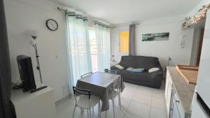 ein Wohnzimmer mit einem Sofa und einem Tisch in der Unterkunft Superbe T2 face mer 4EST402 in Le Barcarès