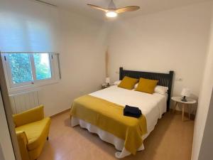 a bedroom with a bed and a yellow chair at La Casa Azul in Maspujols