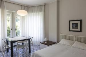 a bedroom with a bed and a desk and a table at Poggio Fiorito in Rapallo