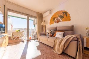 ein Wohnzimmer mit einem Sofa und einem Balkon in der Unterkunft Apartamentos Atlas IV in Salou