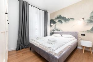 ワルシャワにあるKłobucka 27 by Homeprimeのベッドルーム1室(ベッド1台付)が備わります。壁には絵画が飾られています。