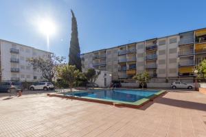 una piscina en un aparcamiento frente a un edificio en Apartamentos Atlas IV, en Salou