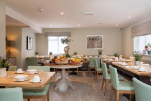 a dining room with wooden tables and green chairs at The Charm Brighton Boutique Hotel & Spa in Brighton & Hove