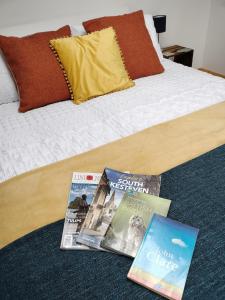 dos revistas sentadas encima de una cama en Private Garden Room - Rural Village, en Stamford