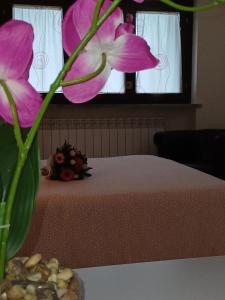 a vase with a pink flower on a table at Monolocale Azzurra in Magione