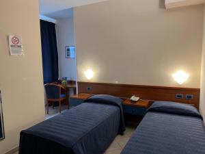 ein Krankenhauszimmer mit 2 Betten und einem Schreibtisch in der Unterkunft 1000 Miglia in Monteroni dʼArbia