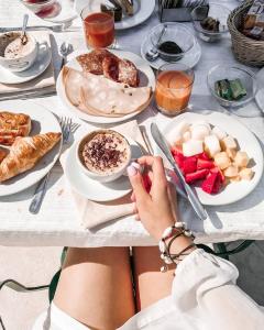 a woman sitting at a table with plates of food at Hotel Villa Bianca in Ischia