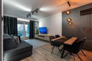 Vip Apartament z klimatyzacją Lubelska في جيشوف: غرفة معيشة مع طاولة وأريكة