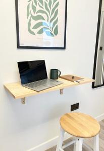 een laptop op een houten plank aan een muur bij Belgrave Studios Hyde Park in Londen
