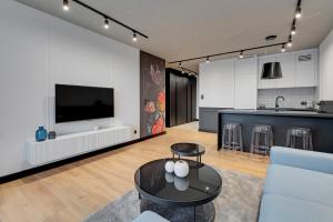 a living room with a couch and a table at Przystań Letnica Seaside by Downtown Apartments in Gdańsk