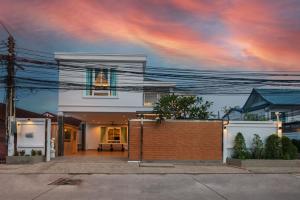 a white house with a brick fence in front of it at Grand Gala Villa in Pattaya South