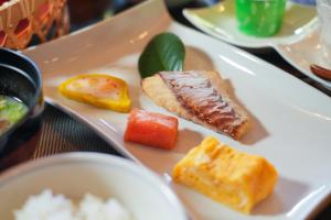 un plato de comida con carne y verduras. en Ryokan Yayanoyu en Ueki