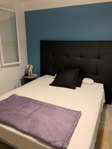 Maison proche Avignon في Barbentane: غرفة نوم مع سرير أبيض كبير مع اللوح الأمامي الأسود