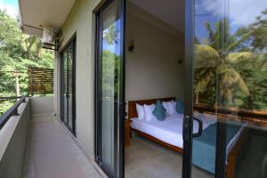 a bedroom with a bed and sliding glass doors at Hidden Heaven in Dickwella