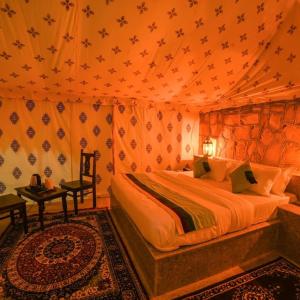 a bedroom with a bed in a tent at The Taj of Desert in Sām