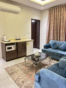 阿可賀巴的住宿－Maset Al Masem Al Khobar，客厅配有2张蓝色的沙发和1张桌子