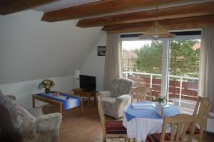 a living room with a table and chairs and a window at Kiebitzei in Wittdün
