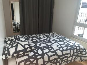 1 dormitorio con 1 cama con edredón blanco y negro en Appartement cosy, en Lyon