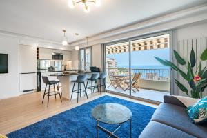 a living room with a couch and a kitchen with a view at Baie de Monaco, Vue Mer, Terrasse, Parking Gratuit - AF in Beausoleil