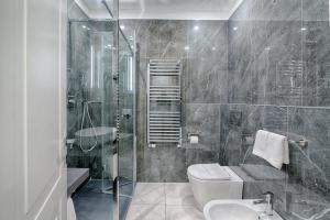 y baño con aseo, lavabo y ducha. en Home Grifondoro Affittacamere, en Génova