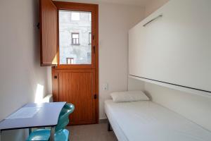 a small room with a bed and a desk and a window at Casa de Colònies Casa Pare Coll in Gombreny +27 photos