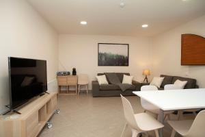 a living room with a couch and a tv at Casa de Colònies Casa Pare Coll in Gombreny