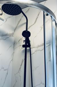 a shower with a black shower head in a bathroom at East Bridgford Summerhouse Inc Spa and Treatments in East Bridgford