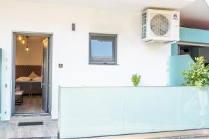 Habitación con pared blanca, microondas y cama en Serenity Luxe Suites en Parga