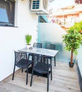 a table and chairs on the balcony of a house at Serenity Luxe Suites in Parga