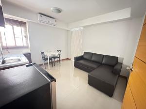 a living room with a black couch and a table at Wangkaew Suite Hotel in Phitsanulok