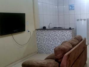 a living room with a couch and a flat screen tv at casa com ar condicionado e garagem in Pirapora