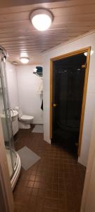 baño con puerta negra y aseo en Puotipuisto, en Ylivieska 3 fotos más