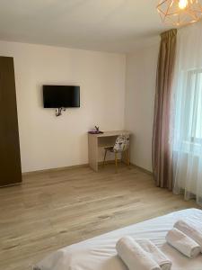 a bedroom with a bed and a television on the wall at InnTime in Cluj-Napoca