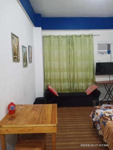 a room with a table and a window with a couch at 8 JOAQUIN'S Place WIFI Free! in Antipolo