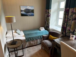 ソンダルにあるHofslund Fjord Hotelのベッドと椅子付きの小さな部屋です。