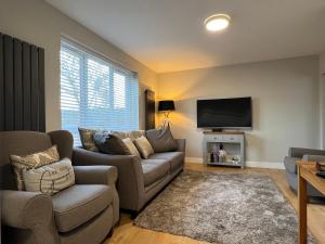 a living room with a couch and a flat screen tv at Immaculate Newly Refurbished 4 Bed House in Nottingham