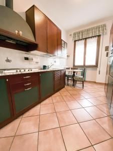 cocina grande con armarios marrones y mesa en La casa di Jacopo [Intero appartamento+parcheggio], en Pistoia