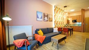 un soggiorno con un divano blu e un tavolo di Apartamenty Every Sky Szklarska Poręba - Kilińskiego 17A-17B-17C a Szklarska Poręba