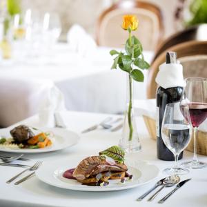 een tafel met twee borden eten en een glas wijn bij Pałac Polanka in Krosno
