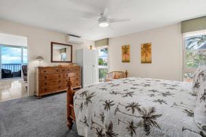 a bedroom with a bed and a dresser and windows at Nani Kai Hale A209 in Kihei
