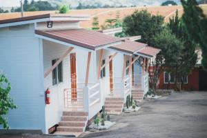 a row of houses with stairs and trees at DE VARIS KHAOKHO in Ban Non Na Yao +2 photos